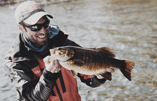 Erik Thue holds a large bass fish